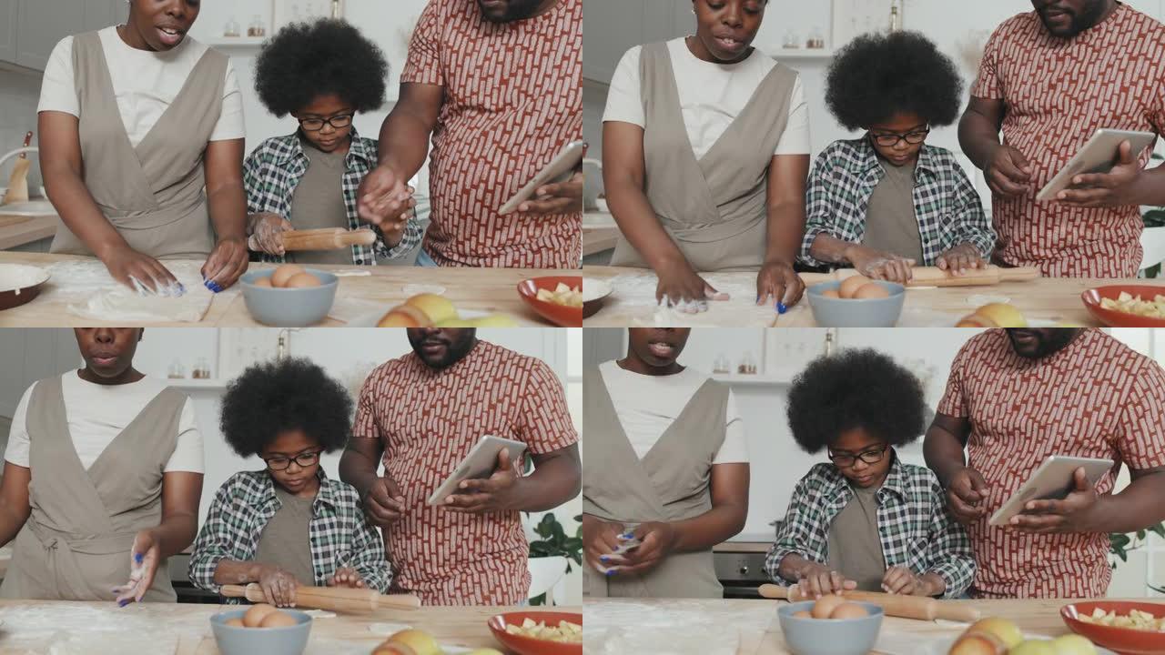 非裔美国男孩在家与父母一起做苹果派