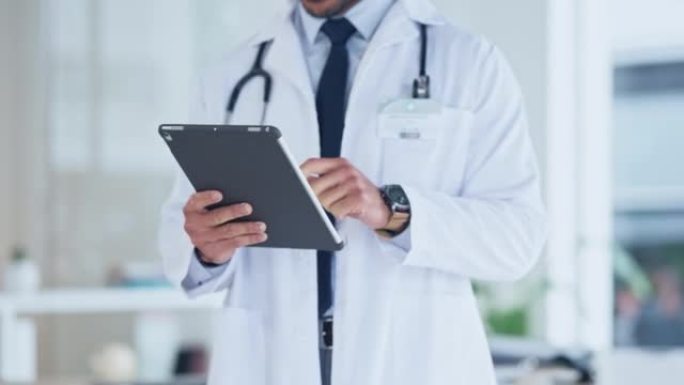 医生在医院使用平板电脑的手。在诊所中使用无线设备的医疗保健专业人员的特写镜头。GP在线研究医学的最新