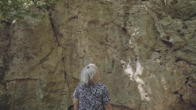 高级女性冒险老年人旅游夕阳红老人查看岩石