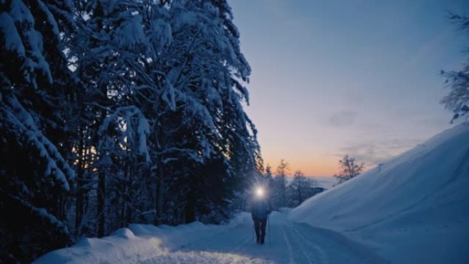 SLO MO徒步旅行者在积雪覆盖的乡间小路上行走时戴着头灯