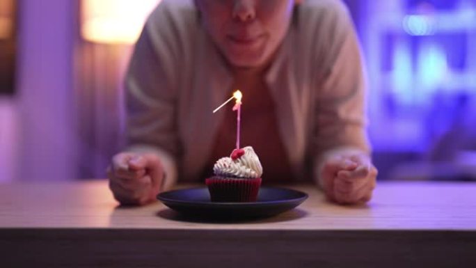 女人许愿，吹灭生日蛋糕上的蜡烛