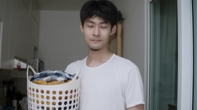 时髦的亚洲男子在家洗衣服