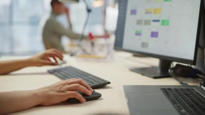 关闭女人的手在键盘和显示器上工作的镜头。年轻女子的手移动电脑鼠标和打字。女销售经理制定时间管理计划。