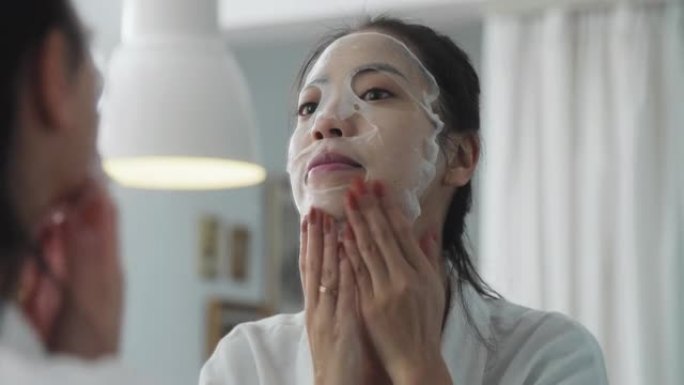 年轻亚洲女性护肤脸镜贴面膜