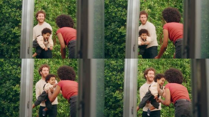 爱的混血家庭在现代家中与可爱的男婴玩耍，挂在花园里。开朗的父母养育孩子。童年、新生活、为人父母的概念