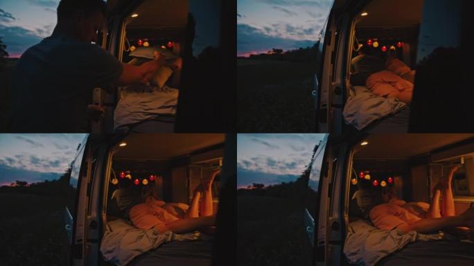 WS夫妇在黄昏时停在草地上的露营车内准备床上用品