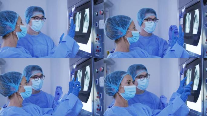 不同的男性和女性外科医生戴着手术帽和口罩讨论x光