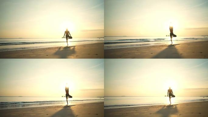 海滩上美丽的瑜伽女人的剪影