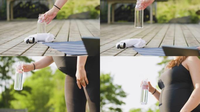 孕妇运动后拿起一瓶水