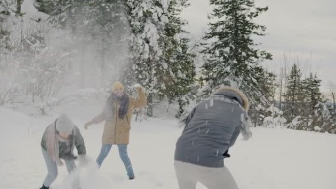 一群朋友在森林里玩雪球和欢笑冬天的日子