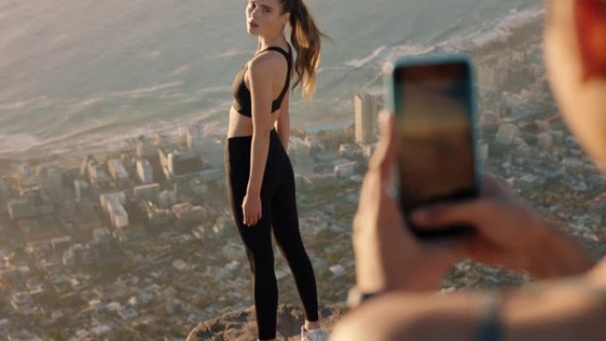 女性朋友使用智能手机相机在山顶拍照美丽的有影响力的女性在社交媒体上用手机为朋友摆姿势分享徒步旅行冒险
