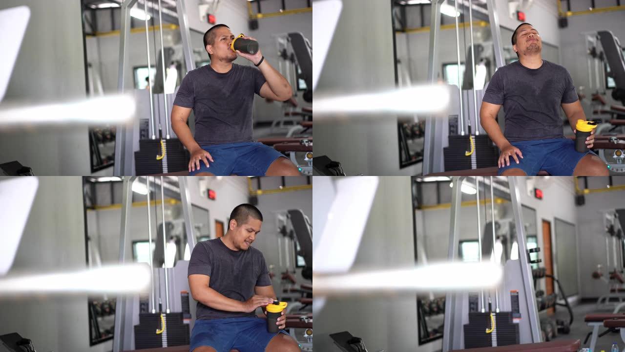 健身亚洲男子在锻炼后喝蛋白质奶昔，为身体和肌肉获得营养