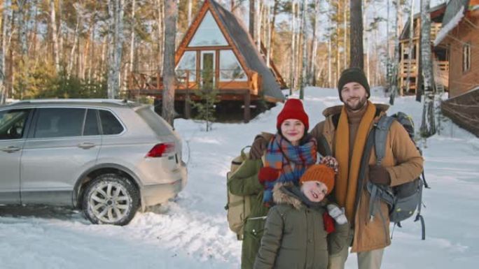 冬天舒适小屋前幸福家庭的肖像