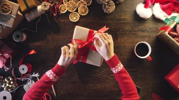4k视频片段，一个无法识别的女人独自坐在工作室里包裹着圣诞节礼物
