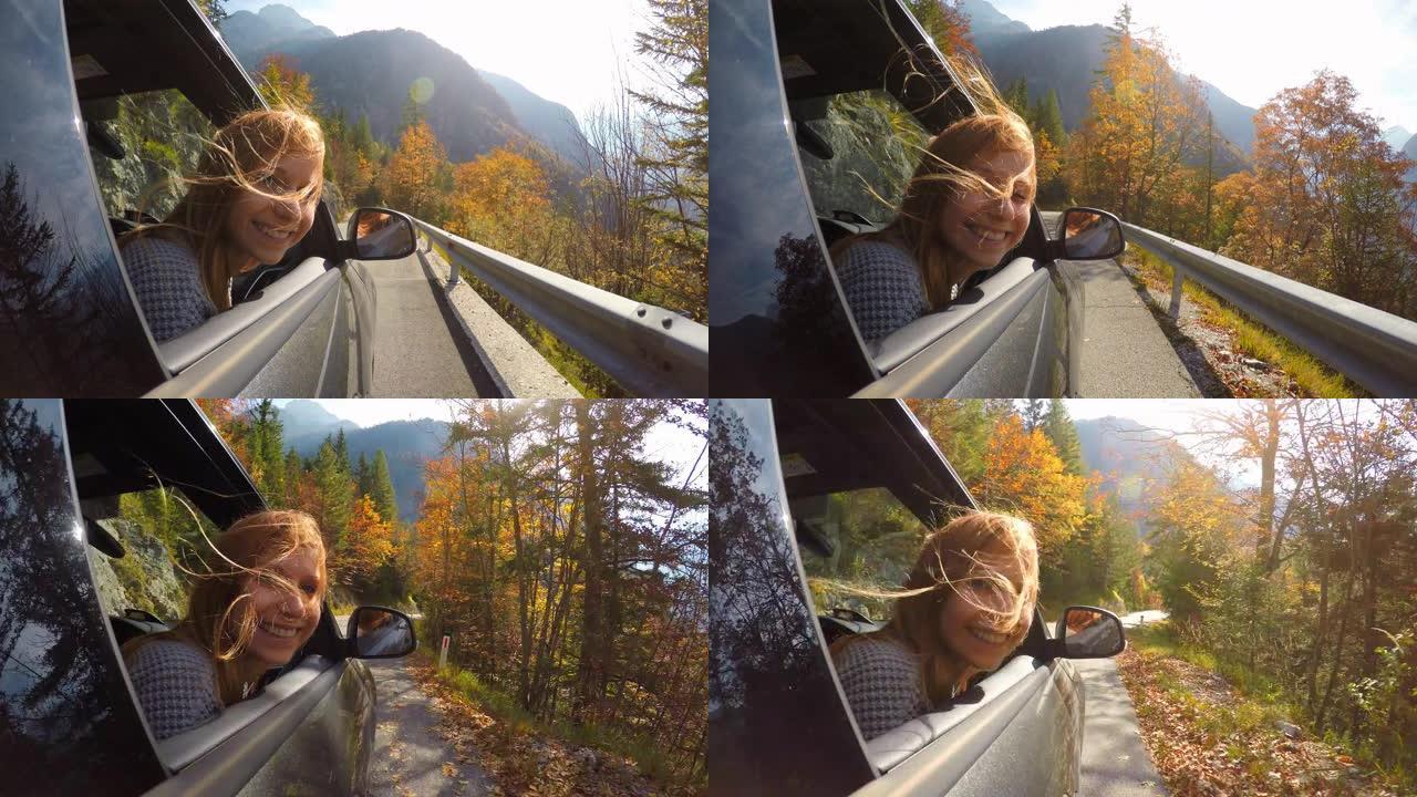 女人在穿越秋天的森林时从车窗外倾斜