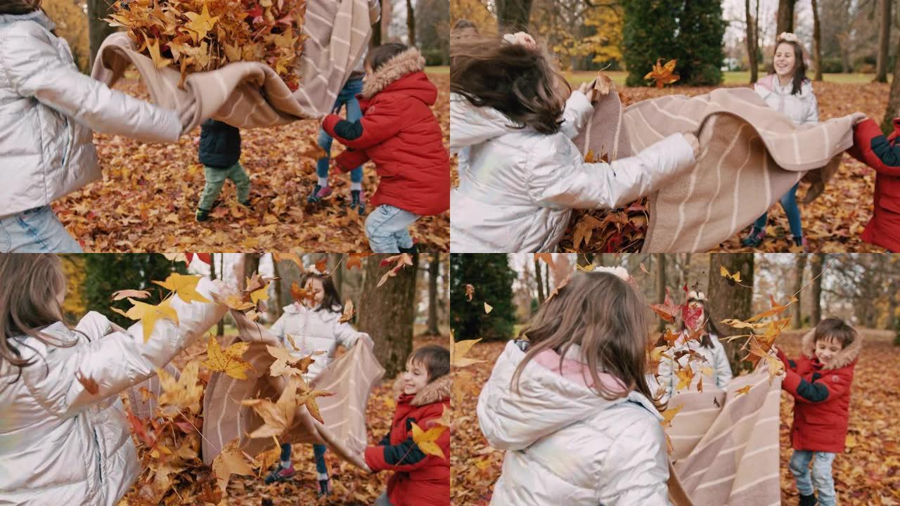 孩子们在公园里拿着秋叶毯子