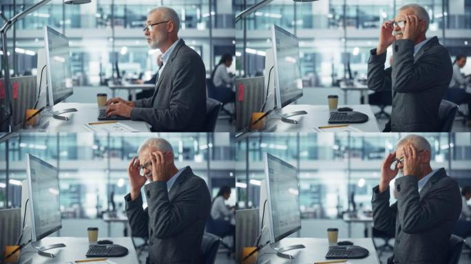 高级白人男性公司办公室工作人员在电脑上工作，感到突然疼痛、头痛、偏头痛。会计师感到项目压力，压力，按