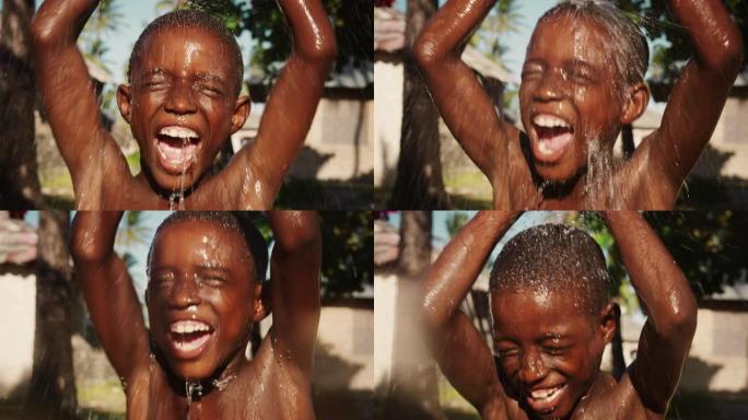 一个非洲小男孩在倾盆大雨下蹦蹦跳跳的肖像。在漫长的干旱和炎热的天气后，快乐而天真的黑人孩子们玩耍和享