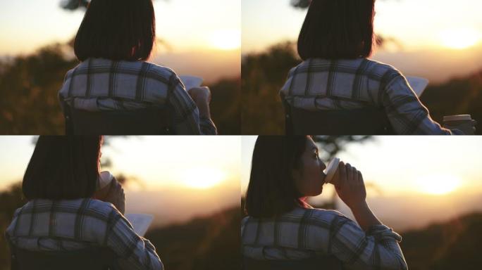 日落时分，女人在山上用咖啡杯户外放松