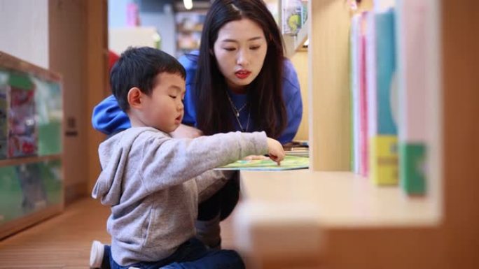 母亲和男孩在图书馆看书
