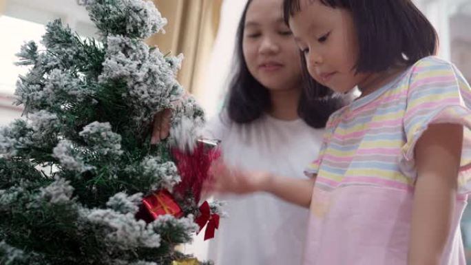 4K UHD手持年轻亚洲女孩装饰圣诞装饰品，妈妈为节日快乐做准备。