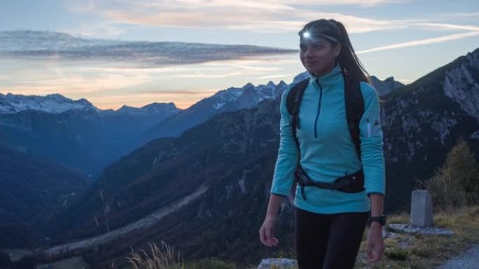 健康导向的女人晚上在山口路上徒步旅行