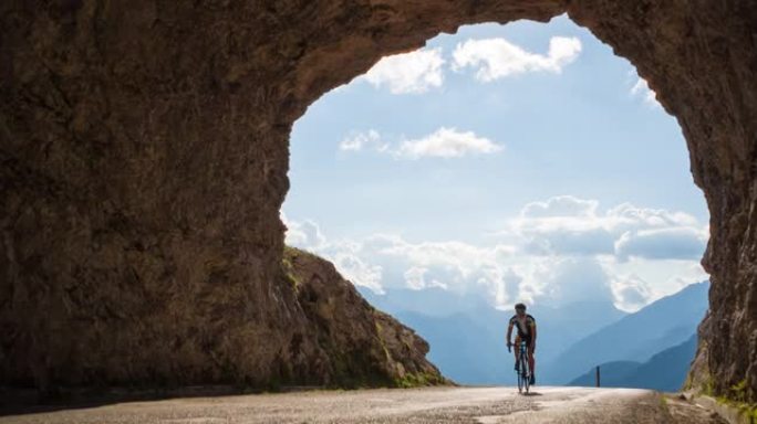 公路骑自行车的人骑在山路上，穿过岩石隧道