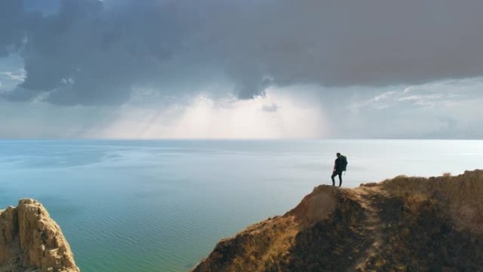 游客站在海景背景上的山崖上