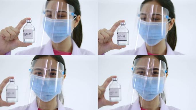 一位年轻的女医生为新型冠状病毒肺炎拿起疫苗瓶的焦点传达了一种希望，即疫苗可以通过平移和利用侧面的光线