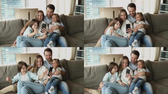 夫妇和孩子在沙发上放松，使用智能手机玩得开心