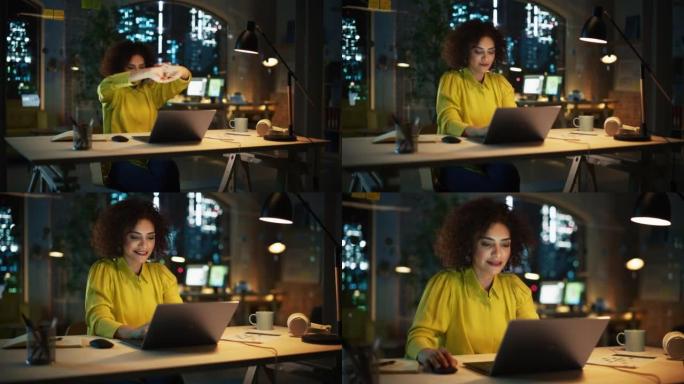 受启发的多种族女性在办公桌前伸展，有动力开始在办公室的笔记本电脑上工作。快乐项目经理写创意文本，浏览