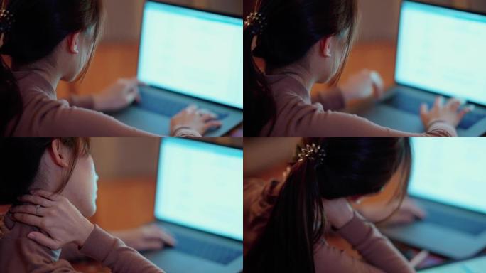 昏昏欲睡的亚洲女性半夜坐在家里的办公桌前，在笔记本电脑和数字平板电脑上看书。