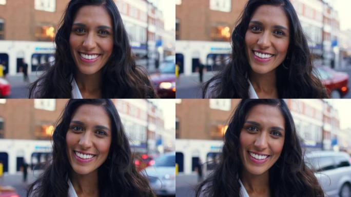 4k视频片段，一个美丽的年轻女子快乐地站在繁忙的街道上