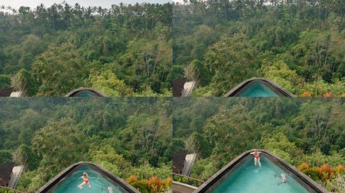 上图性感女人在热带酒店水疗中心无限泳池游泳，丛林景观享受异国情调的暑假奢华生活方式，无人机飞行4k