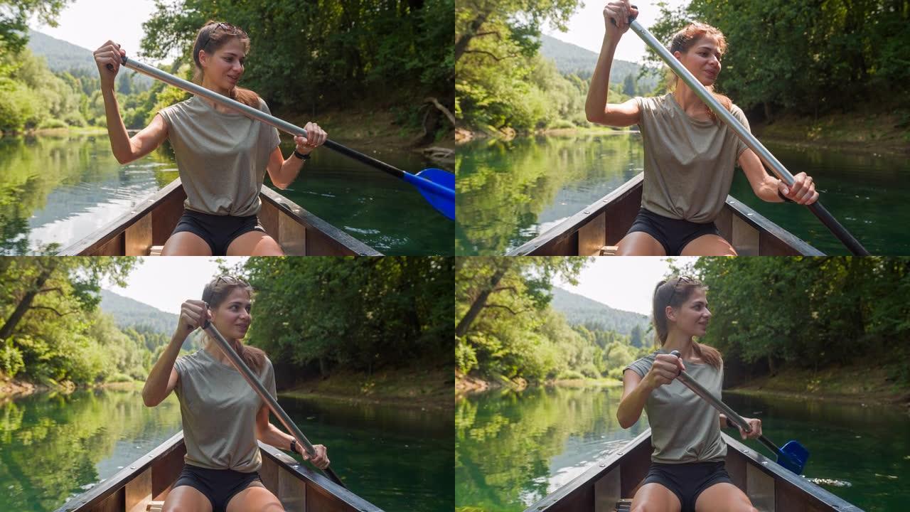 年轻女子乘独木舟，在美丽的夏日划着河