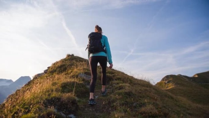 年轻的健身女子保持健康，在山上高高的空气，沿着山脊走