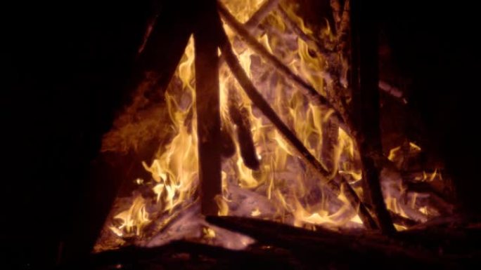 慢动作: 燃烧的大块木头堆放在篝火中，闷烧的余烬