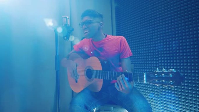 年轻的非裔美国人在录音室弹吉他和唱歌