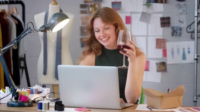 时尚企业的女老板，在工作室的笔记本电脑上播放一杯葡萄酒视频通话