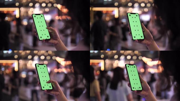 女人晚上使用绿屏智能手机