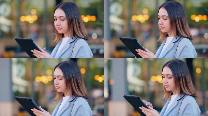 一位年轻的女记者在城市街道上的户外平板电脑上写了一个故事。一位年轻时尚的女性新闻记者在博客中输入了一