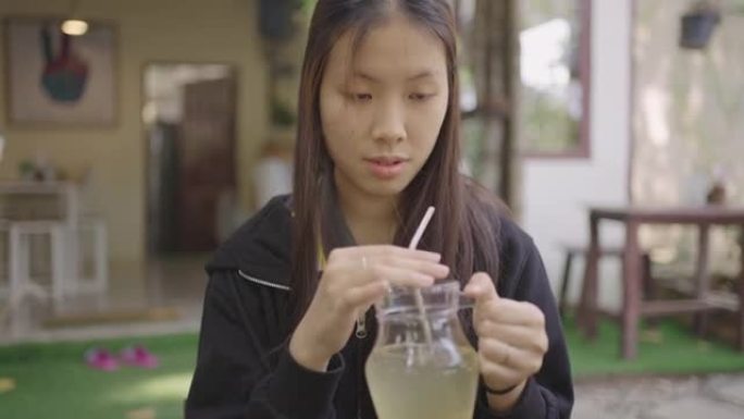 年轻的亚洲妇女享受她的一杯草药饮料