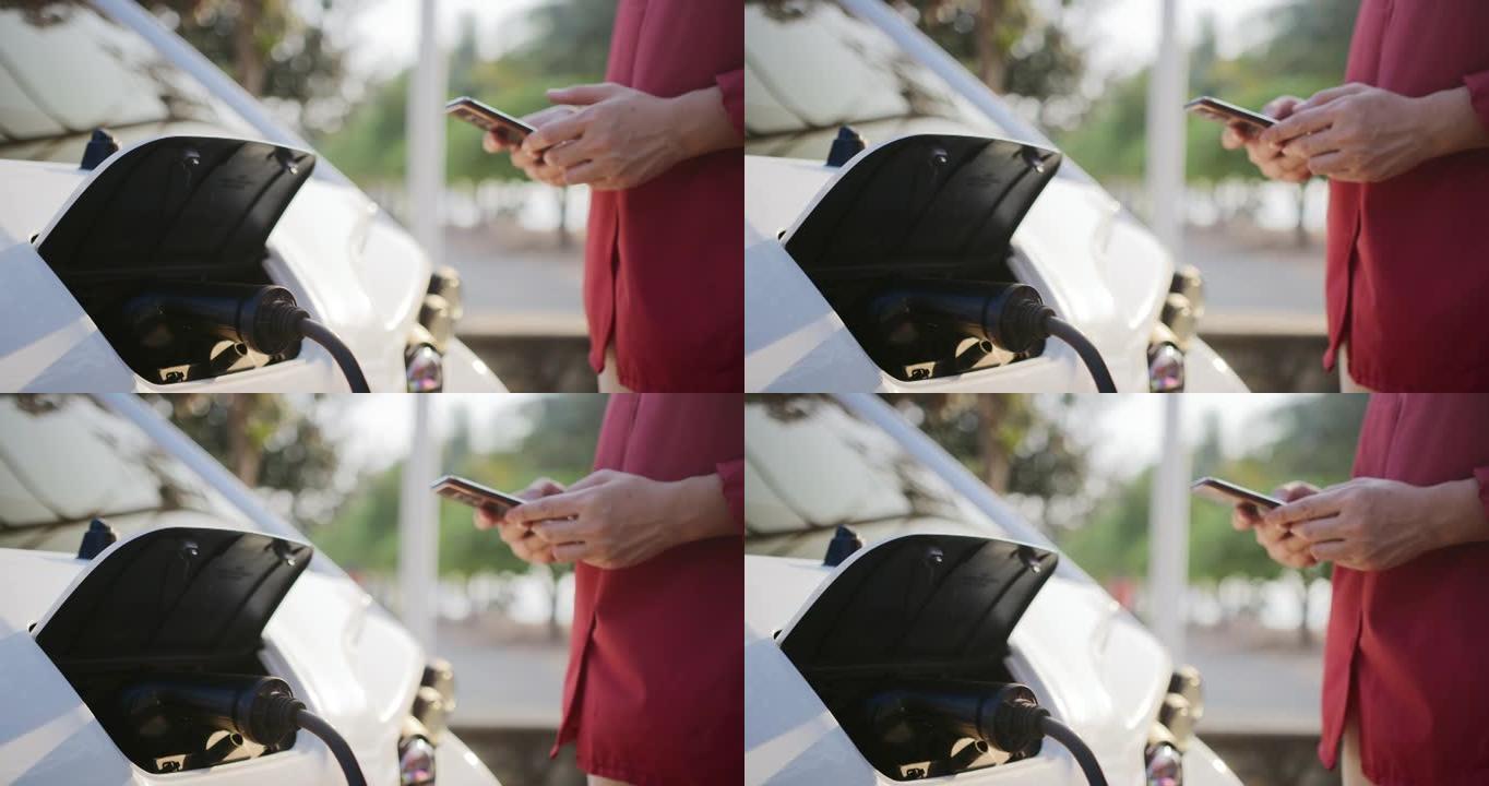 使用智能手机检查电池汽车状态的清洁能源无法识别的女人