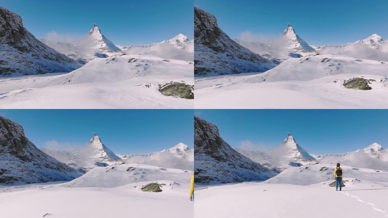 站在瑞士马特宏峰山顶上的旅行者年轻女性的空中无人机视图。大自然中的幸福。具有多样性概念的体验式旅行。