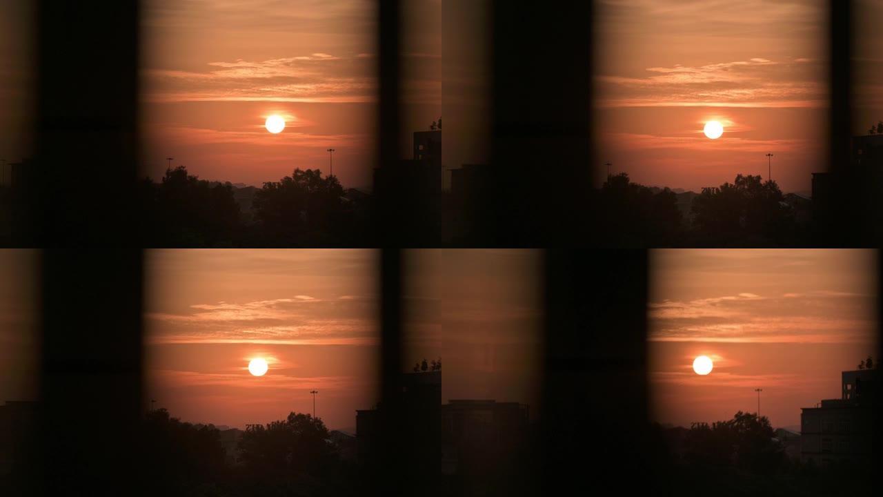 日落透过窗户看城市，日落太阳在窗户上反射