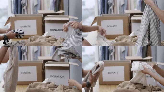 两个人折叠衣服并将其包装在捐款箱中的4k视频片段