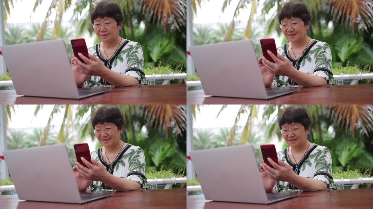 老年女性在户外使用笔记本电脑和手机