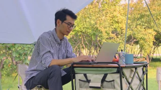 露营度假期间使用笔记本电脑的人