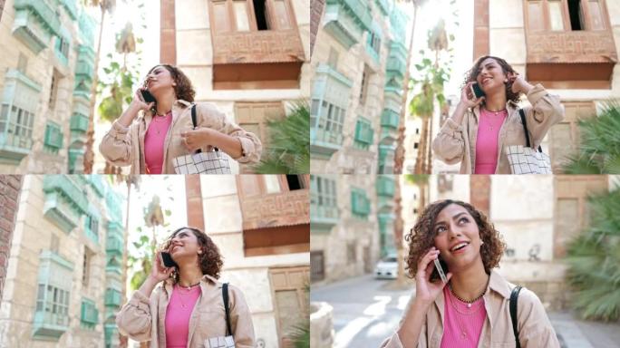 微笑的中东妇女在户外使用智能手机
