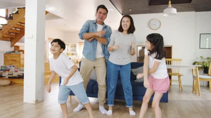 慢动作 -- 快乐的亚洲家庭在现代家庭的客厅听音乐和跳舞。